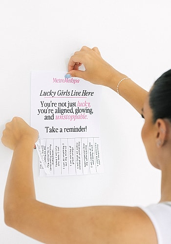 Skincare professional with motivational sign background.