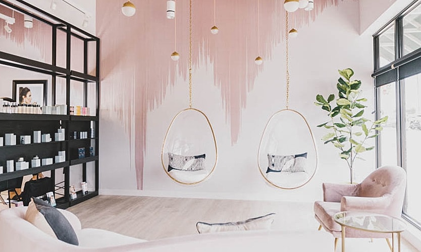 Chic interior with hanging chairs and pink decor.