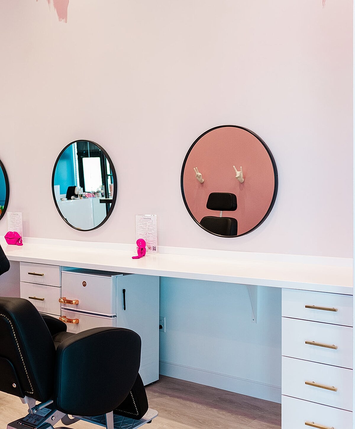 Woman examining lips in mirror at clinic.