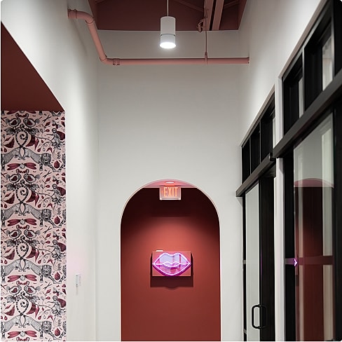 Colorful hallway with neon lips artwork.
