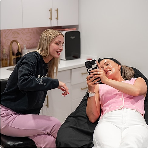 Beautician applying treatment to client's eyelashes.
