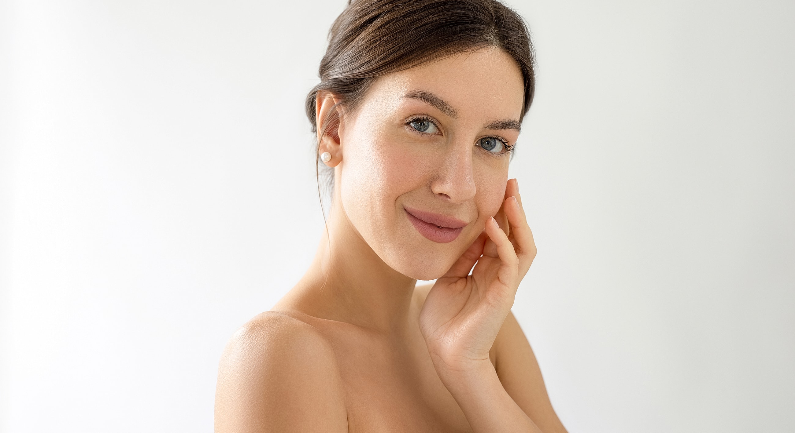 Woman applying skincare product on her face.